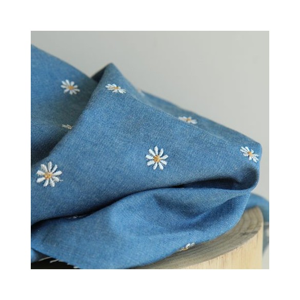tissu denim bleu brodé de pâquerettes